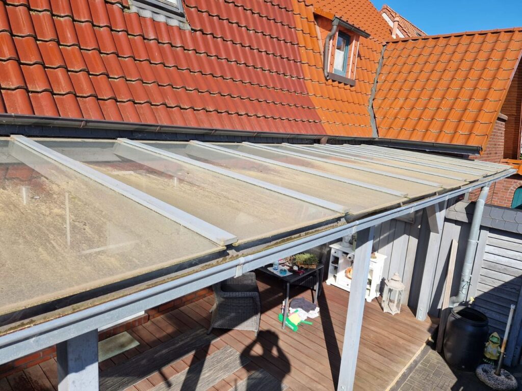 Terrassenüberdachung in Bremen-Borgfeld vor der Reinigung – Glasdach mit Moos und Algen